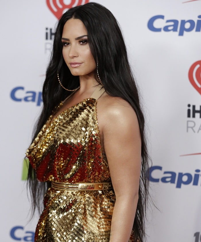 Demi Lovato's makeup by Jill Powell was golden bronze while her long dark hair was parted down the middle