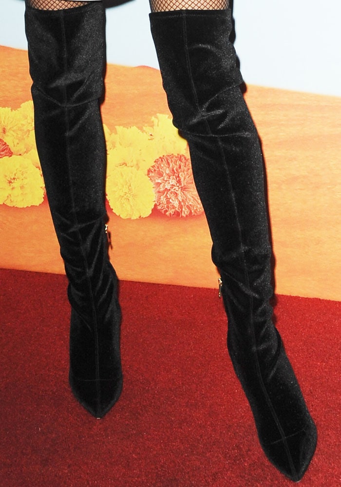 The model showcased Stella Luna’s black velvet over-the-knee “Sleek” boots paired with fishnet stockings
