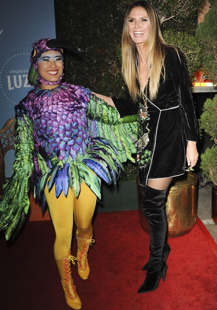 Heidi Klum shared a playful red-carpet moment with a feathered Cirque du Soleil performer before heading inside for the show