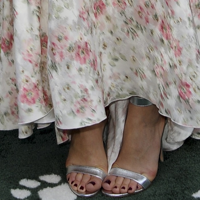 A close-up of Margot Robbie’s feet in metallic silver Gianvito Rossi 'Portofino' sandals, showcasing the minimalist two-strap design