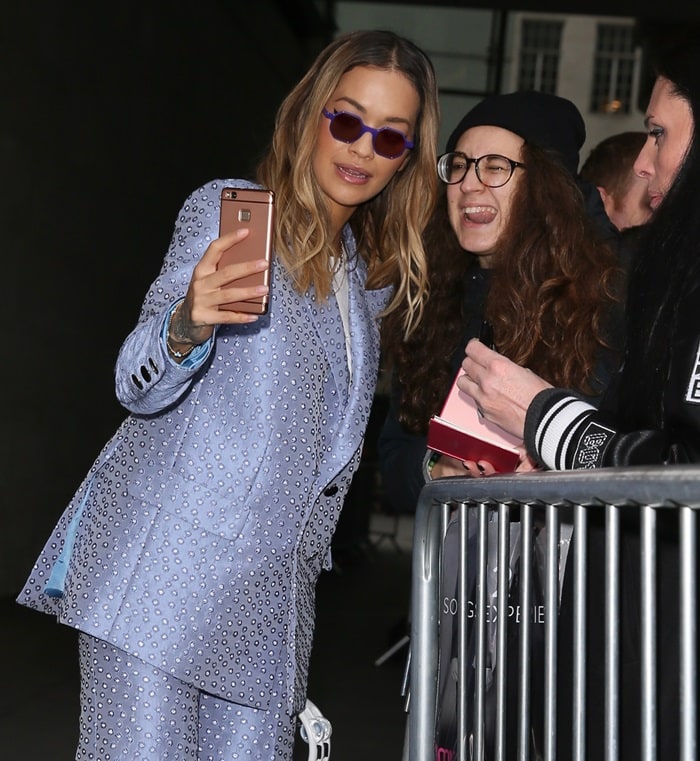 Rita Ora wearing a polka dot suit from the Palomo Spain Spring 2018 collection and carrying a tambourine as she arrives for an interview at BBC Radio 1 in London on December 4, 2017