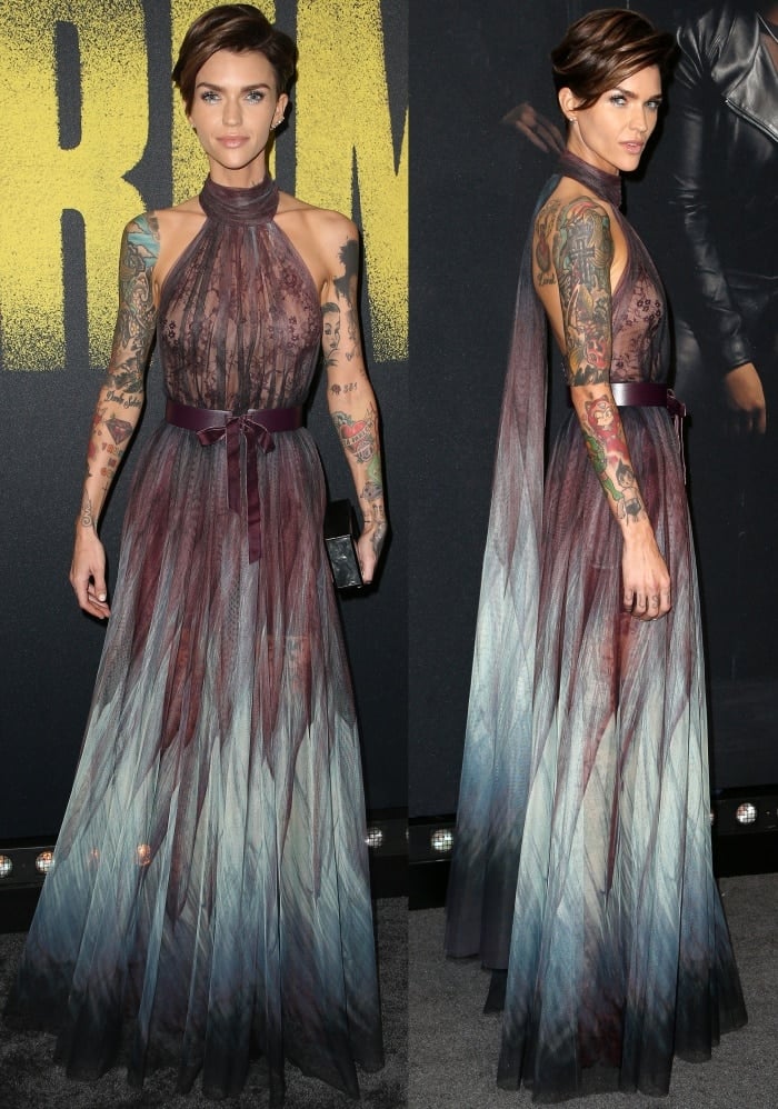 Ruby Rose turns heads in a sheer ombré Elie Saab gown with a halter neckline and plum satin belt, showcasing her tattoos through layers of flowing tulle