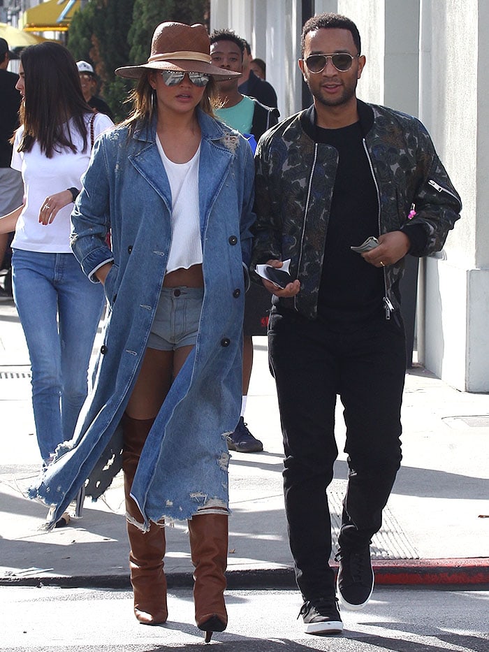 John Legend keeps it sleek in a camo-print bomber jacket layered over a classic black tee, paired with slim-fit trousers and black low-top sneakers for a polished yet casual street-style look