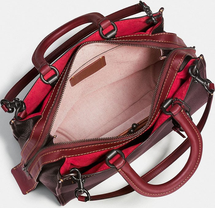 Inside view of a genuine Coach Rogue bag, showcasing suede panels, organized compartments, and reinforced stitching that reflect the brand’s meticulous leather craftsmanship