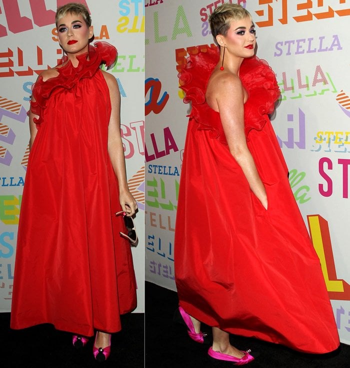 Katy Perry makes a dramatic entrance in a voluminous red Stella McCartney Spring 2018 dress, with flashes of hot-pink footwear peeking beneath the ankle-grazing hem