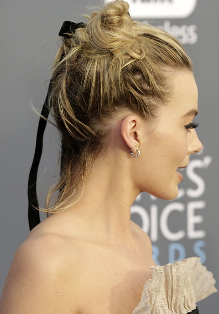 A black velvet ribbon softened Margot Robbie’s loose knotted updo, adding a romantic finish to the structured Chanel look