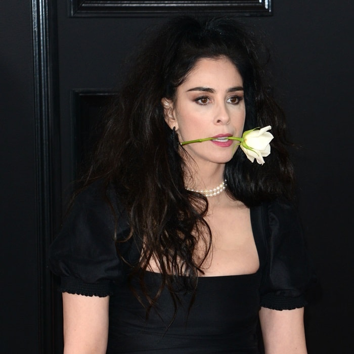 Sarah Silverman makes a bold statement by holding a white rose between her teeth