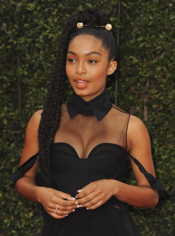 Yara Shahidi captivates in a sheer black gown with structured detailing complemented by delicate jewelry