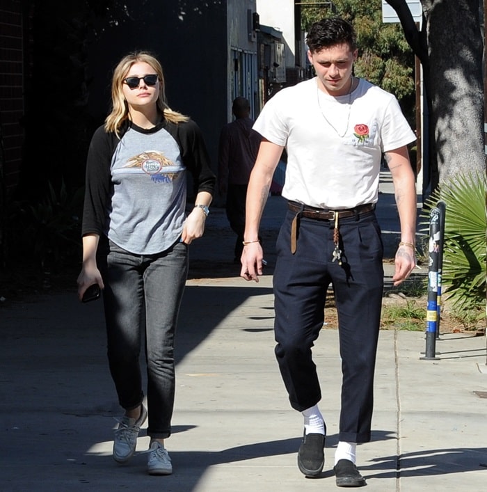 Chloë Grace Moretz keeps it casual in classic white Reebok sneakers, while Brooklyn Beckham complements her laid-back vibe with black slip-on loafers and ankle-grazing trousers