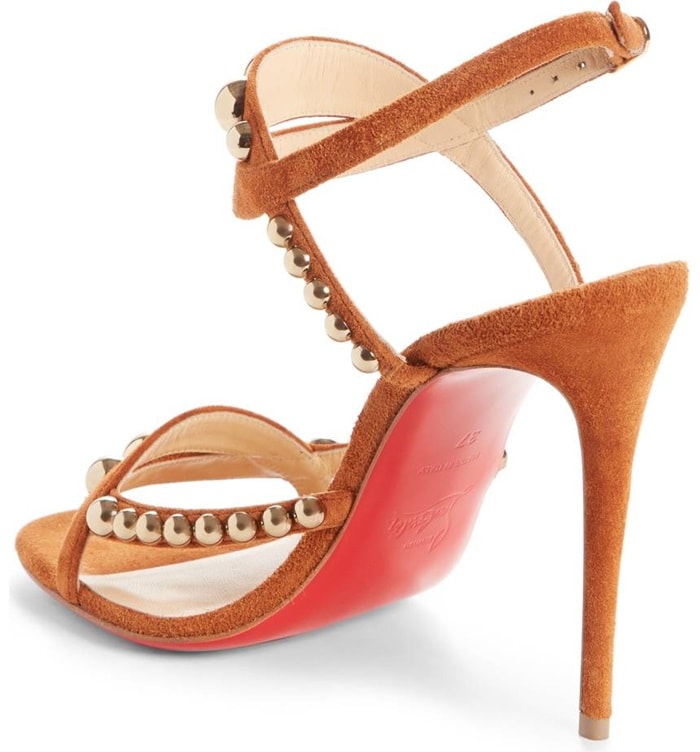 Arcs of burnished dome studs bring shimmer and dimension to the curvy contours of a day-to-evening sandal