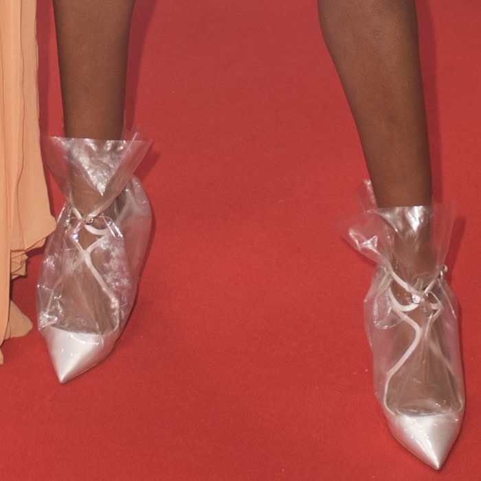 Damaris Lewis effortlessly rocks the Claire 100 plastic bag pumps in white satin
