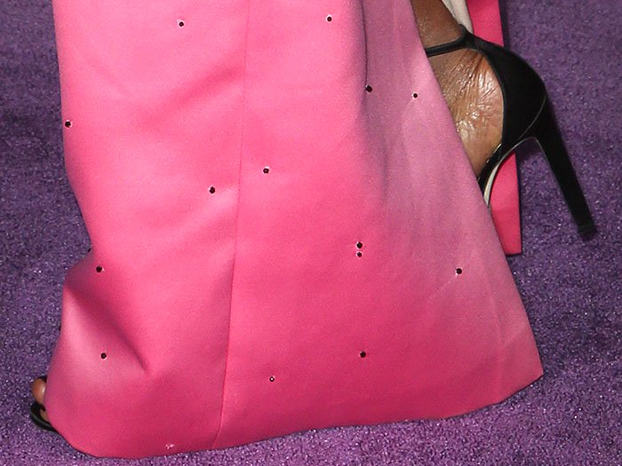 Closeup of the black satin ankle-strap sandals on Danai Gurira
