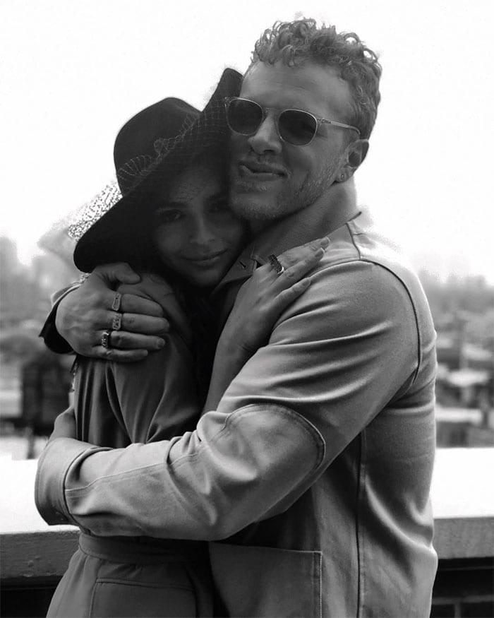 Emily Ratajkowski and Sebastian Bear-McClard embrace after their surprise wedding at New York City Hall, with Emily wearing a black netted fedora and Sebastian sporting sunglasses