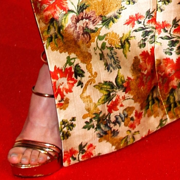 The gown’s sweeping hem opens just enough to showcase her gleaming platform heels on the red carpet