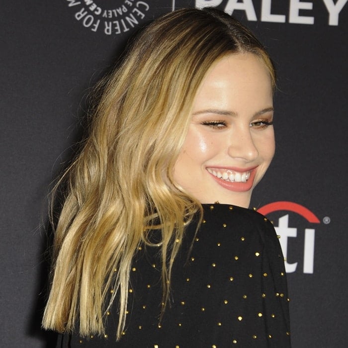 Halston Sage flashes a radiant smile and loose waves on the PaleyFest red carpet in Hollywood