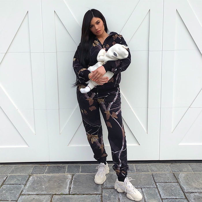 Kylie Jenner steps out with Stormi on March 1, 2018, in a coordinated Alexander Wang winter camo fleece hoodie and pants, paired with Yeezy 500 Desert Rat sneakers in Blush