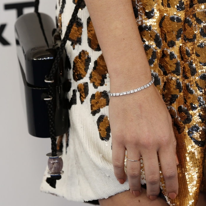 Diamond Tiffany T jewelry and a structured black The Row bag add polished contrast to the dress’s bold leopard pattern and shimmering sequins