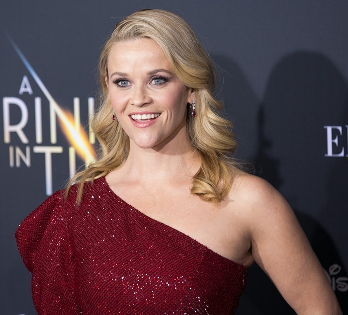 Smiling on the blue carpet, Reese highlights the gown’s sculpted shoulder detail and crystal-embroidered fabric that catches the light with every movement