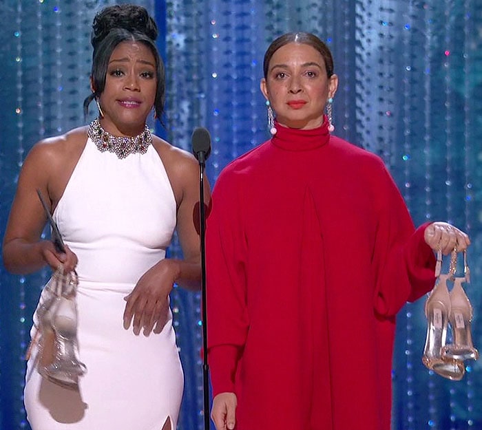 Tiffany Haddish and Maya Rudolph with their shoes in their hands while presenting at the 2018 Oscars.
