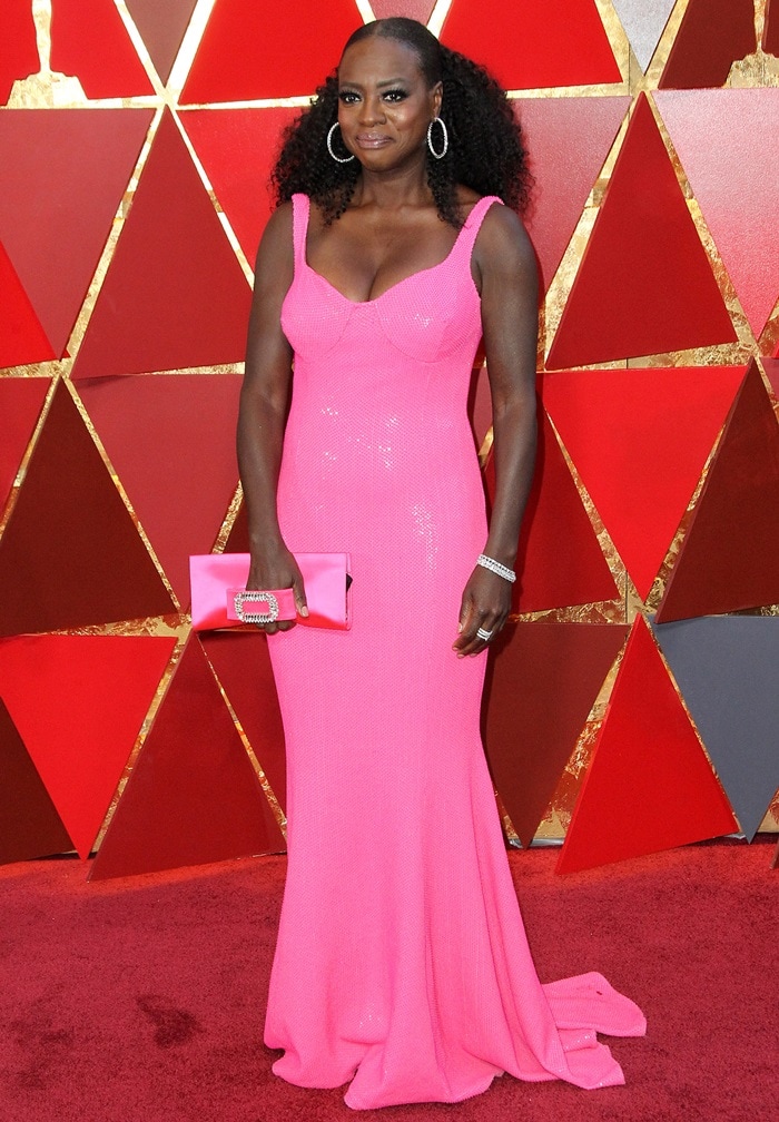 Viola Davis lit up the 2018 Oscars red carpet in a jaw-dropping hot pink Michael Kors gown, styled with a Roger Vivier clutch, while her sweeping hemline concealed the heels that undoubtedly completed her glamorous look