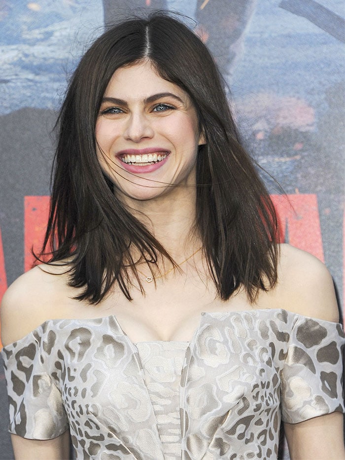 Alexandra Daddario flashed a radiant smile in her Zac Posen leopard-print off-shoulder gown at the "Rampage" LA premiere, with her striking blue eyes adding to the elegance of her look