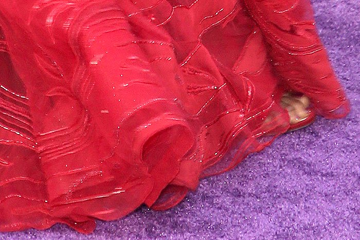 Glittery, red Jimmy Choo sandals peeking out from underneath Danai Gurira's red Zuhair Murad gown.
