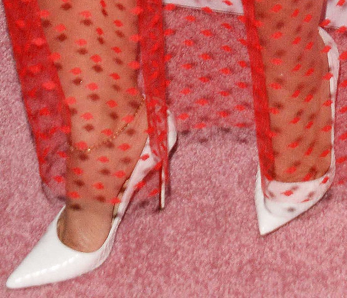 Close-up of Dascha Polanco’s feet in white python Christian Louboutin “So Kate” pumps, styled with a sheer red polka-dot dress at Beautycon 2018