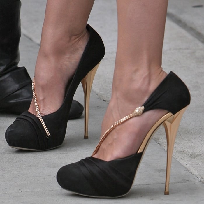 Heidi Klum steps out in sky-high black satin pumps accented with a delicate snake-embellished chain, the razor-thin gold stiletto amplifying the shoe’s dramatic, leg-lengthening effect