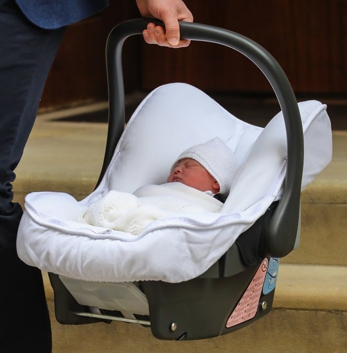 Prince Louis peacefully rests in a car seat as he makes his first public appearance outside the Lindo Wing