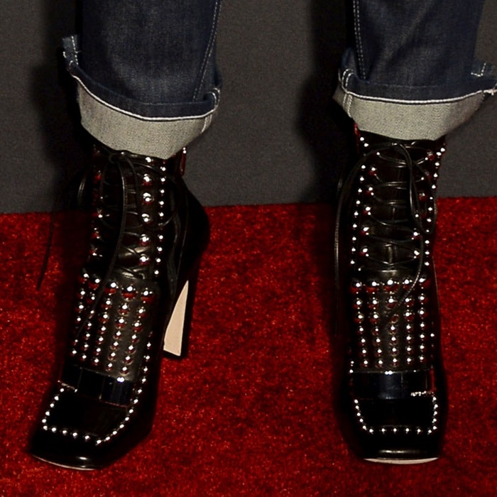 Zosia Mamet's bold footwear choice featured black patent Sergio Rossi 'SR1' ankle boots, adorned with silver studs for a striking red carpet statement