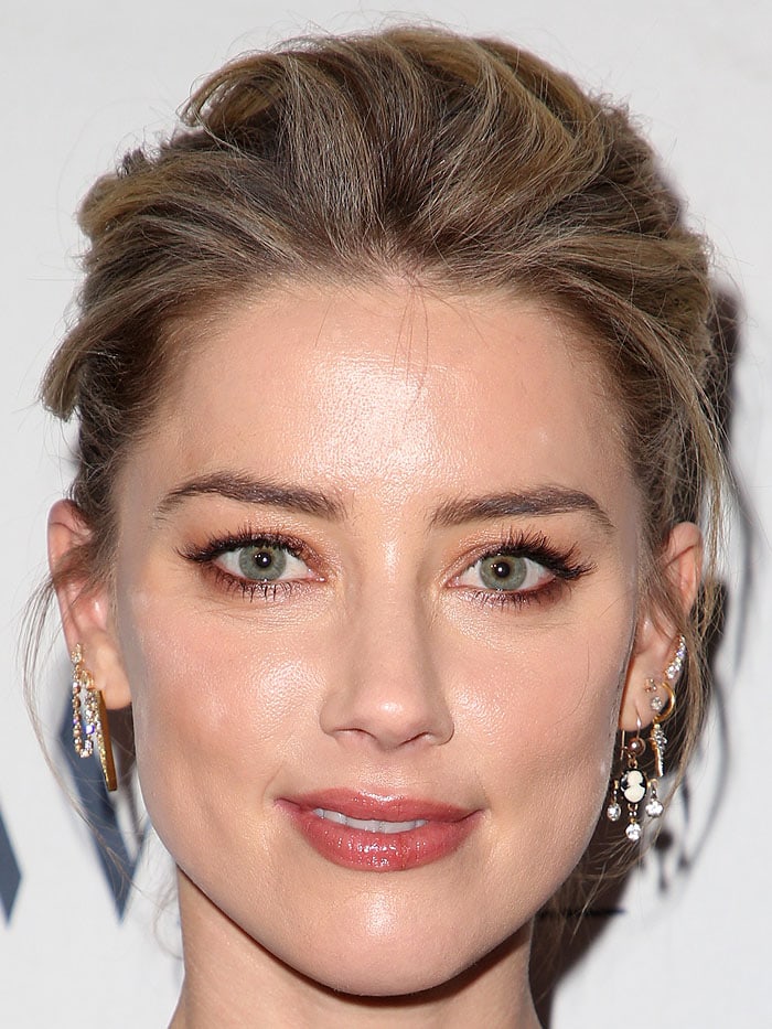 Amber Heard showcasing a stunning array of delicate gold and diamond earrings