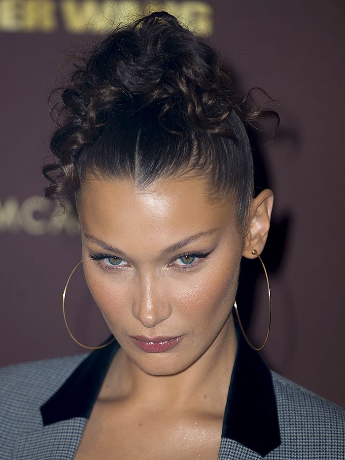 Bella Hadid’s bold updo adds volume and texture, perfectly paired with statement Jenny Bird large hoop earrings