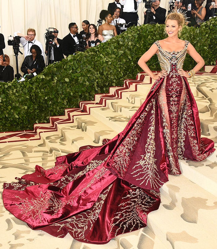 Blake Lively in an Atelier Versace jeweled-bodice red-and-gold gown with a long train, custom Christian Louboutin embellished peep-toe platform sandals, and Lorraine Schwartz halo and jewelry at the 2018 Met Gala