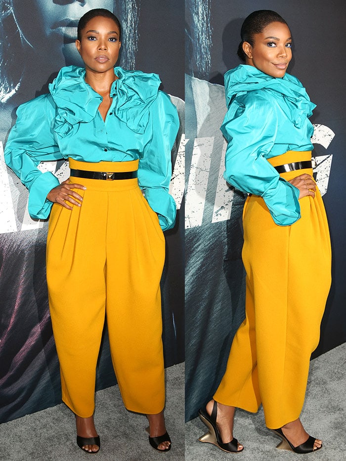 Gabrielle Union turns heads in a vibrant Marc Jacobs ensemble featuring a structured turquoise blouse, bold mustard-yellow trousers, and sleek Salvatore Ferragamo curved-wedge sandals