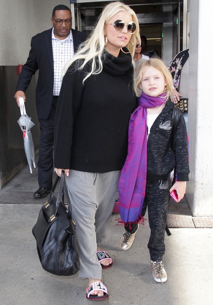 Jessica Simpson pairs gray sweatpants with a black sweater and Fendi studded sandals, while her daughter Maxwell sports a casual tracksuit and gold sneakers at LAX