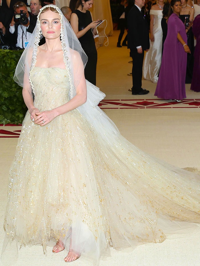 Kate Bosworth wore a voluminous, gold-gilded Oscar de la Renta gown paired with a pearl-embellished veil, channeling bridal elegance in a non-wedding setting