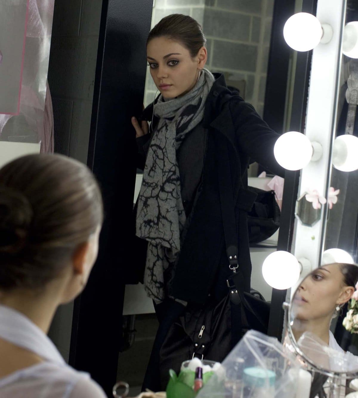 Mila Kunis, as the enigmatic Lily, confronts Natalie Portman’s Nina in a tense backstage moment from Black Swan — a scene that captures the film’s haunting blend of rivalry and reflection