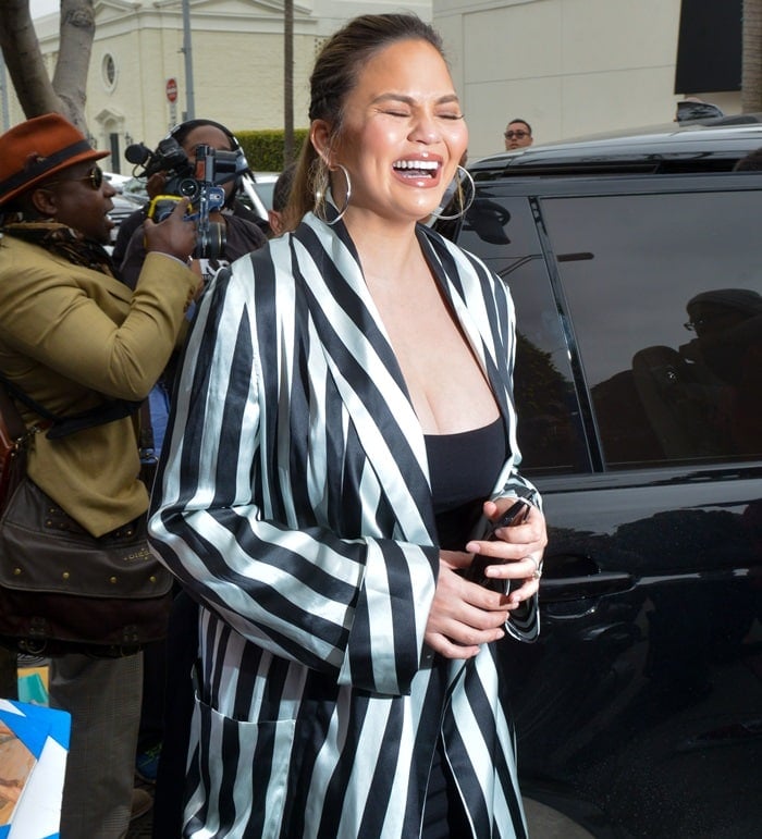 Chrissy Teigen's black and white stripe long sleeve midi robe jacket from Ann Demeulemeester