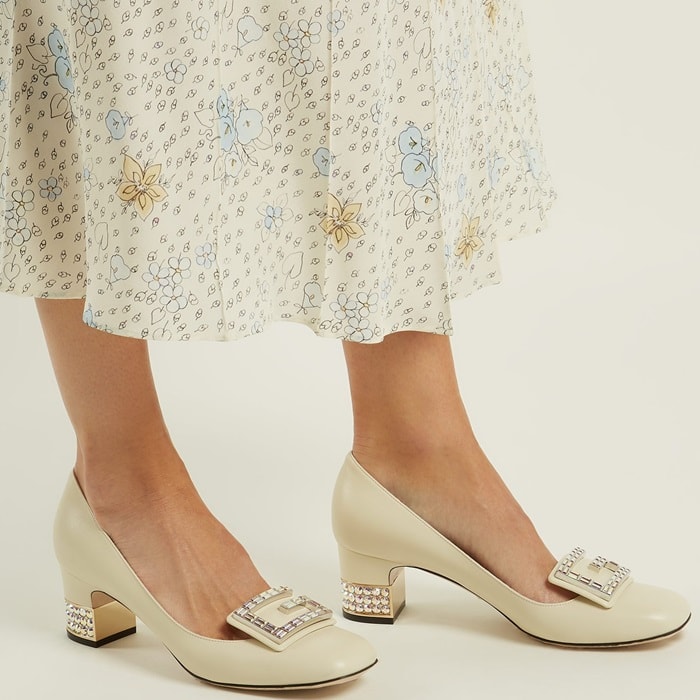 These off-white leather pumps are crafted in Italy to a rounded square-toe silhouette and set on a gold-tone metal block heel encrusted with glittering stones which echo the G-shaped plaque on the front