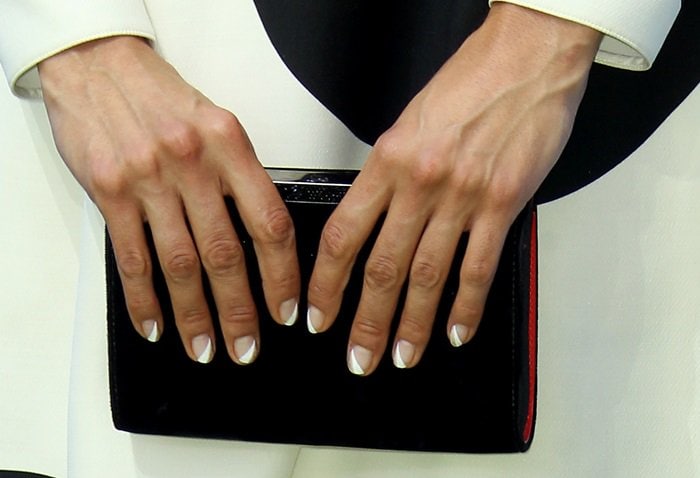 Nina Dobrev's chic geometric manicure adds a modern touch to her black clutch
