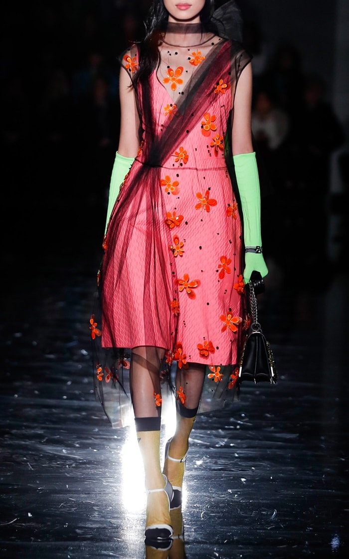 Model wearing Prada gloves featuring a two tone design and feature s long silhouette.