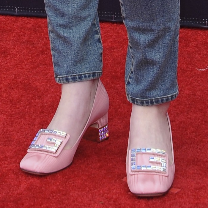 Sadie Sink completes her red carpet look with Gucci's light pink 'Madelyn' silk moiré pumps, featuring a jeweled G-buckle and rhinestone-encrusted block heels