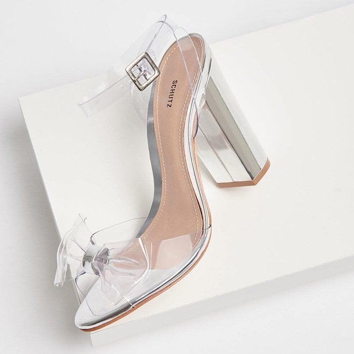 A sleek Schutz Brianne sandal featuring transparent vinyl straps and a sculptural block heel for a modern, minimalist statement