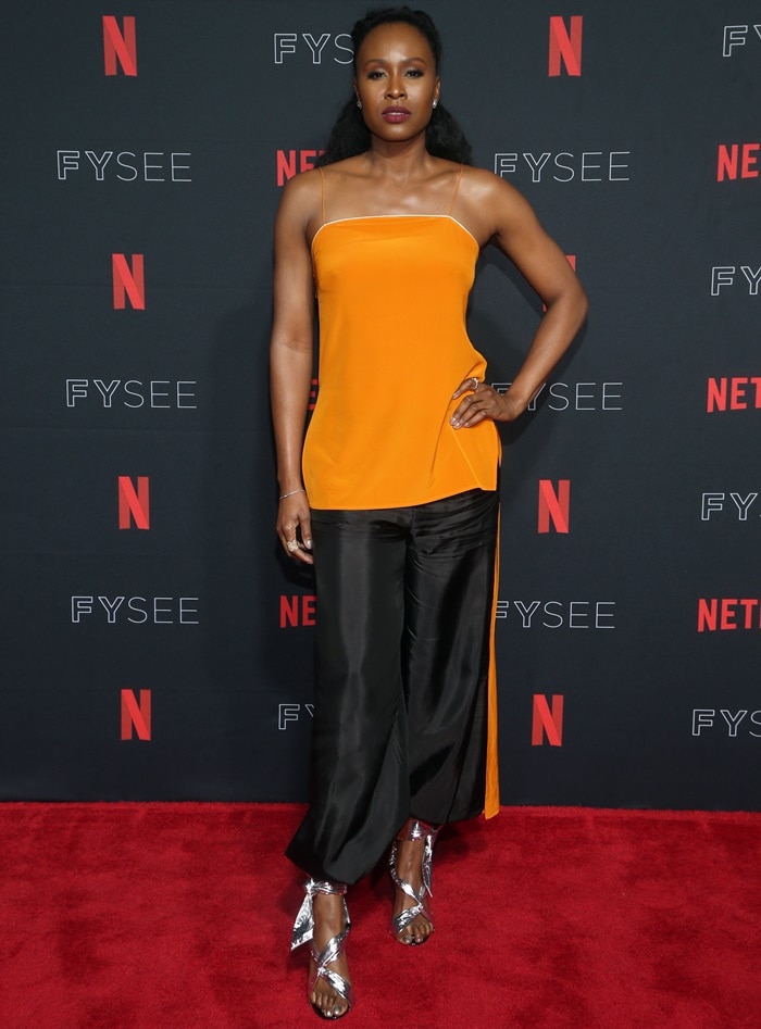 Sydelle Noel’s statuesque frame and athletic build gave dramatic presence to her metallic IRO “Pipa” sandals, whose reflective ankle ties stood out sharply against the red carpet and fluid black trousers at the GLOW Emmy for Your Consideration event