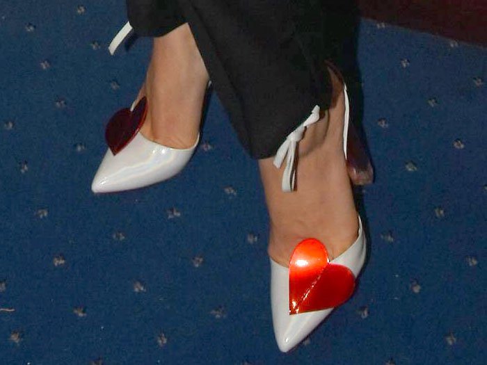 Melissa George in white-patent ankle-tie pumps with red hearts and red-tinted chunky clear heels.