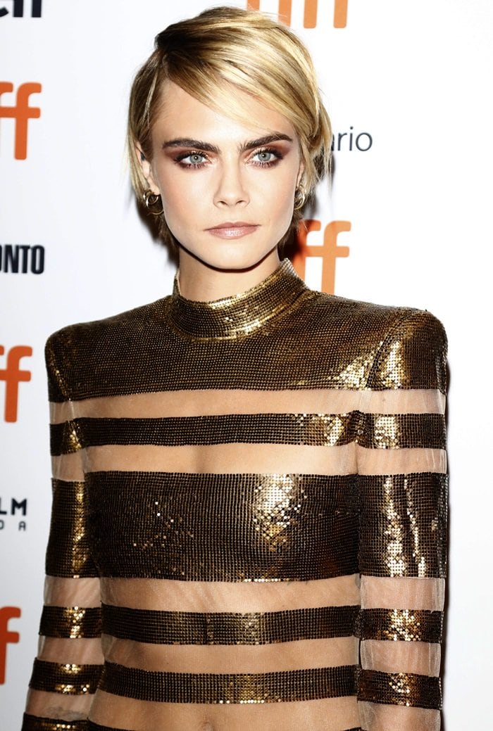 Cara Delevingne's metallic mini dress features risqué sheer paneling throughout