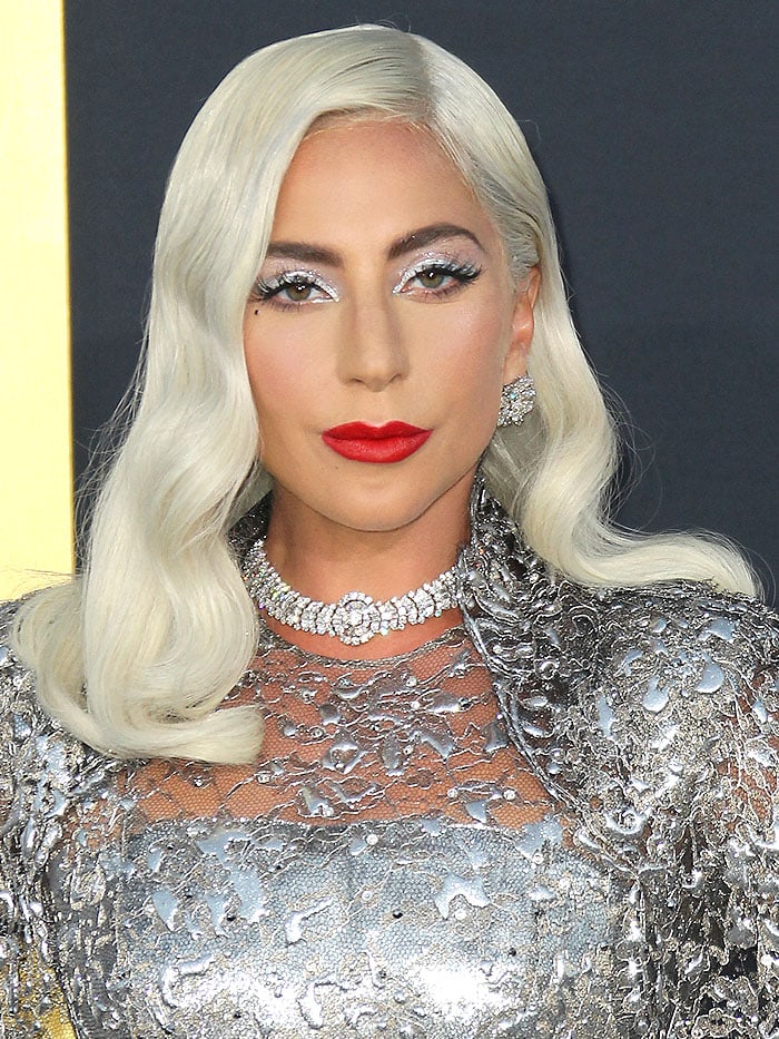 Lady Gaga stuns in sparkling diamond jewelry by Bulgari, including statement earrings and a bold choker necklace, perfectly complementing her silver Givenchy gown