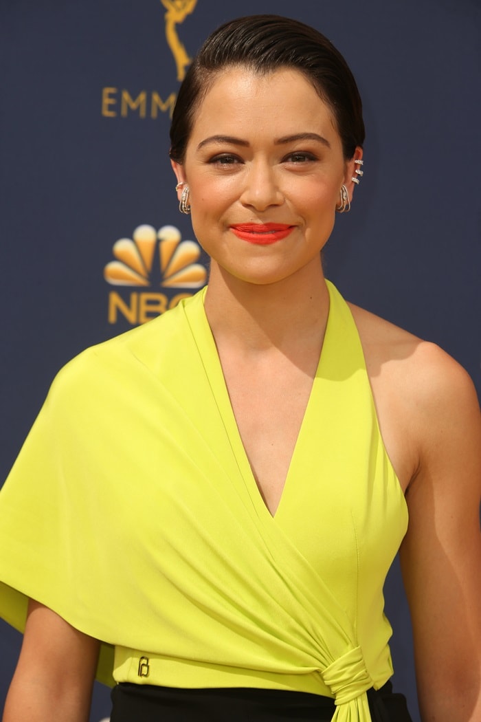 Tatiana Maslany’s glowing beauty look, highlighted by slicked-back hair, coral lipstick, and delicate diamond ear cuffs from Borgioni and EF Collection