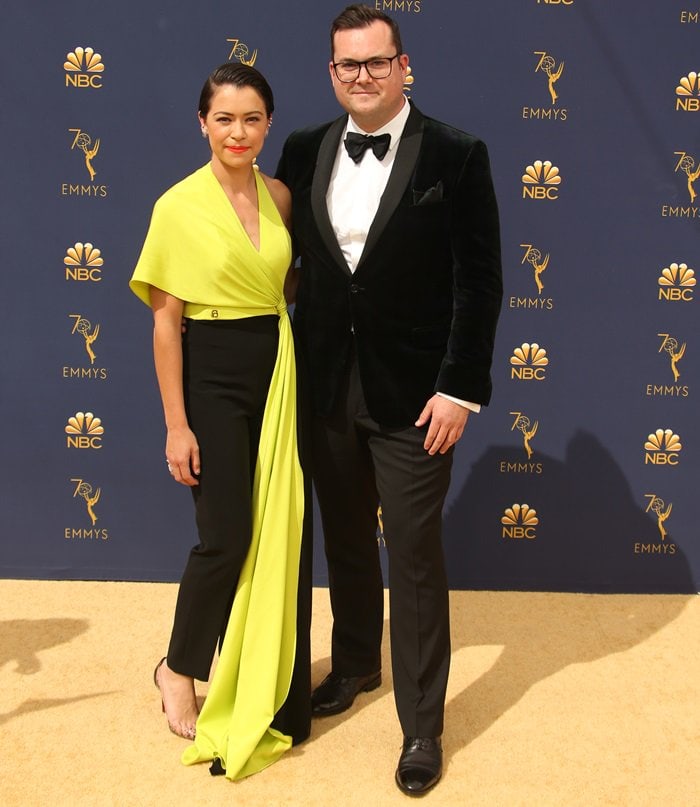 Tatiana Maslany and Kristian Bruun pose together at the 70th Emmy Awards, where Maslany’s neon-yellow Christian Siriano ensemble made a striking red-carpet statement
