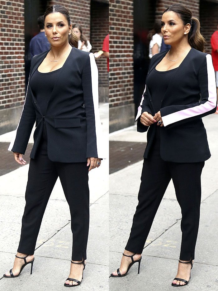 Eva Longoria arriving for her guest appearance on The Late Show with Stephen Colbert in New York City on October 2, 2018, wearing a black tailored blazer with contrasting white stripes on the sleeves, tapered pants, and strappy Gianvito Rossi 'Jaime' sandals